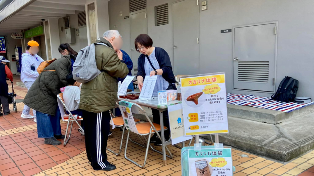 板橋区高島平で開催されたカリンバ体験会の様子。足を止めて楽器に触れる来場者。