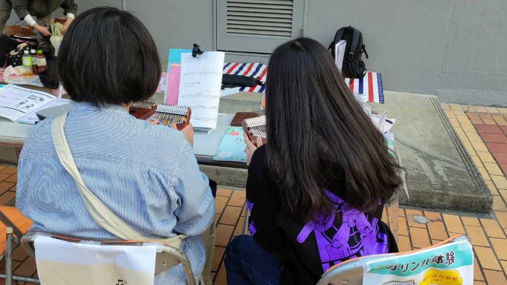 板橋区高島平で開催されたカリンバ体験会の様子。体験会後にカリンバを購入して練習する女の子たち